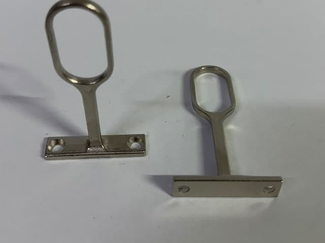 Dos bridas centrales niqueladas para tubo oval, una de frente y otra de lado
